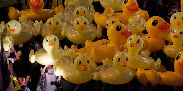 Inflatable yellow ducks, which have become symbols of resistance during anti-government rallies, are lifted over a crowd of protesters in Bangkok, Thailand, on Nov. 27, 2020. A Thai man was sentenced to two years in prison on March 7, 2023, for selling calendars featuring satirical cartoons that a court said mocked the country’s monarch.