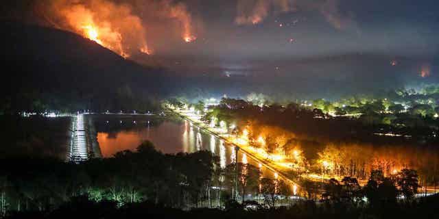 Fire and smoke rise from a forest fire at Nakhon Nayok province, Thailand, on March 30, 2023. The fire had engulfed large areas of two mountains by Thursday.