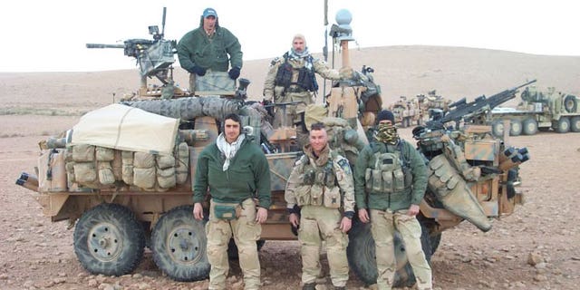 This picture was taken at the border of Saudi Arabia and Iraq right before the initial invasion on March 19, 2003. Pictured standing together on the right are Craig Palmer and Chris VanSant.