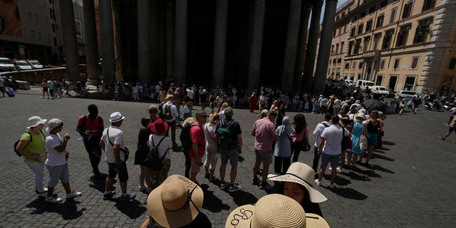 Tourists queue to visit Rome's Pantheon on June 17, 2022. 