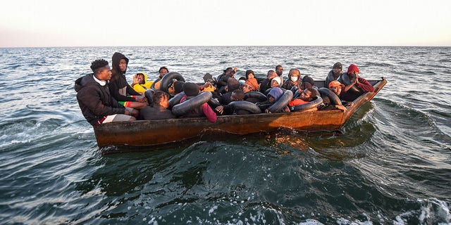 FILE: Migrants from sub-Saharan Africa sit in a makeshift boat that was being used to clandestinely make its way towards the Italian coast. 