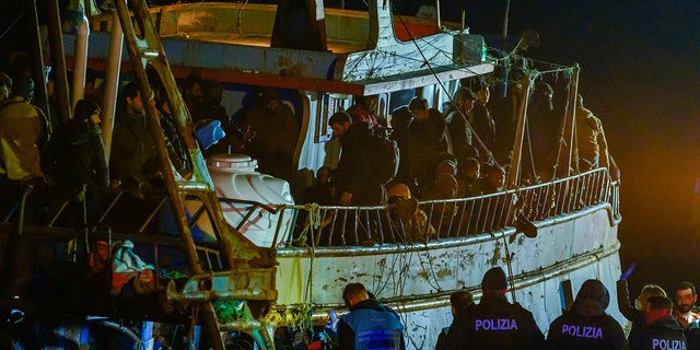 Police check a fishing boat with some 500 migrants in the southern Italian port of Crotone early Saturday. The Italian coast guard was responding to three smugglers boats carrying more than 1,300 migrants "in danger" off Italy’s southern coast.