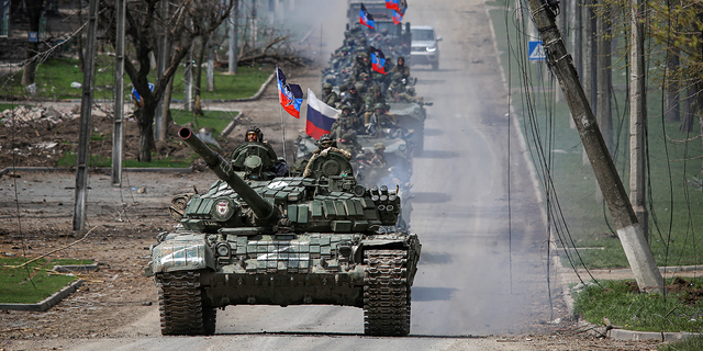 A convoy of pro-Russian troops moves along a road in Mariupol, Ukraine, on Thursday, April 21, 2022.
