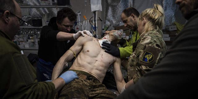Ukrainian military medics treat their wounded comrade at a field hospital near Bakhmut, Ukraine, Feb. 26, 2023.