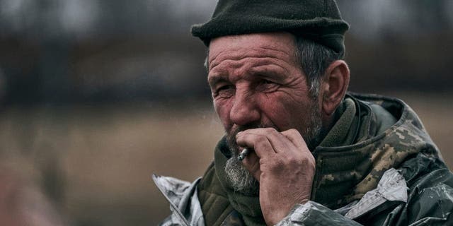 A Ukrainian soldier smokes at the front line near Bakhmut, Ukraine, Tuesday, March 7, 2023.