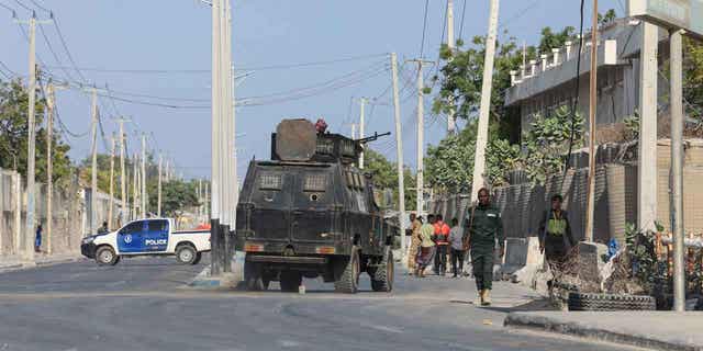 Security forces patrol outside a building which was attacked by suspected al-Shabab militants in the Somalia's capital on Feb. 21, 2023. The United States sent military assistance to Somalia to help fend off the al-Shabab.