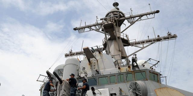 Navy sailors remove the cover of the Phalanx Close-In Weapon System of the USS Milius (DDG-69), a multi-mission capable guided missile destroyer ship docked at the Manila South Harbor on Aug. 18, 2012.
