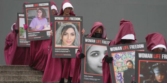 Activists hold placards reading "Woman, Life, Freedom" with portraits of women who were killed in Iran, during a demonstration to mark the International Women's Day, in London, on March 8, 2023.