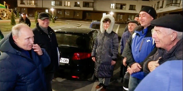 Russian President Vladimir Putin talks with local residents during his visit to Mariupol. 