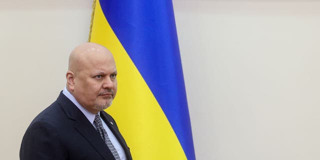 The Prosecutor of International Criminal Court Karim Ahmad Khan stands in front of Ukrainian flag as he visits Kyiv and territories which were occupied by Russia in Ukraine, April 14, 2022. 