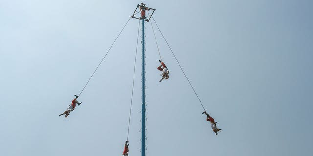 People perform an ancient ritual, Voladores, in Mexico City.