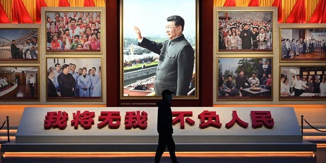 A man walks past a photo of President Xi Jinping at the Museum of the Communist Party of China in Beijing on March 3, 2023, ahead of the opening of the National People's Congress.