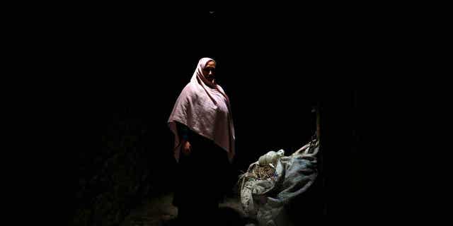 Aziza Rahimi, 35, poses for a photo inside her house in Foladi Valley in Bamiyan, Afghanistan, March 2, 2023. Rahimi gave birth, but her baby died shortly after. 