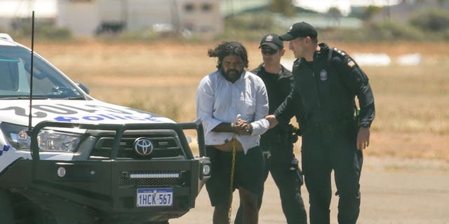 Terence Darrell Kelly, left, boards a plane after being taken into custody by members of the Special Operations Group at Carnarvon airport on Nov. 5, 2021 in Carnarvon, Australia.