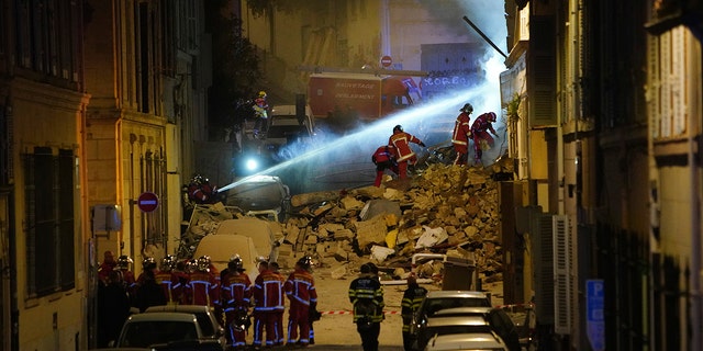 Firefighters worked to extinguish a fire burning under the rubble of residential building that collapsed early Sunday in Marseille, southern France.