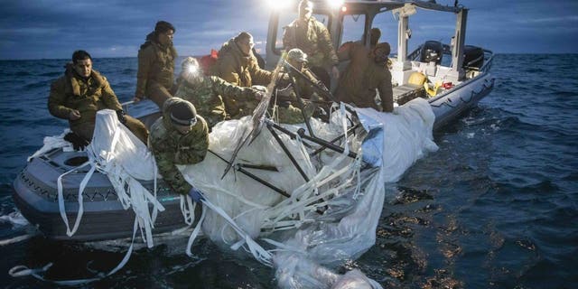 U.S. forces haul debris from China's surveillance balloon onto a boat off the coast of South Carolina.