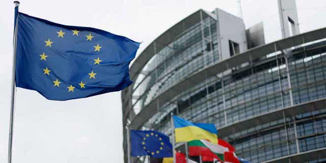 The European flag, left, flies on April 18, 2023, at the European Parliament in Strasbourg, France. EU lawmakers decided Kosovo citizens will be able to travel freely in Europe with visas beginning next year.