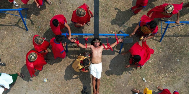 Ruben Enaje is nailed to the cross during a reenactment of Jesus Christ's sufferings as part of Good Friday rituals on April 7, 2023, in the village of San Pedro, Philippines.