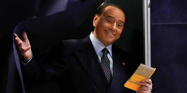 Silvio Berlusconi comes out of a voting booth before casting his ballot at a polling station in Milan, Italy, on Sept. 25, 2022. Berlusconi's health is improving after being hospitalized last Wednesday. 