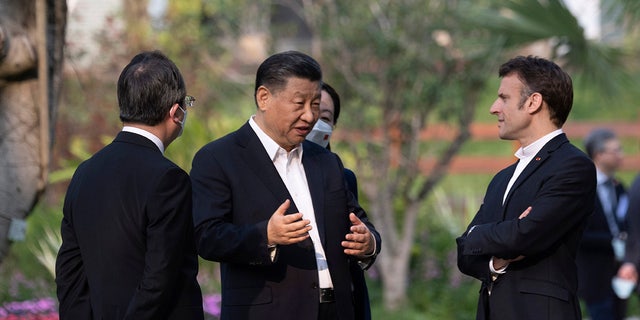 Chinese President Xi Jinping and French President Emmanuel Macron talk in the garden of the Guandong province governor's residence, in Guangzhou, China, Friday, April 7, 2023.
