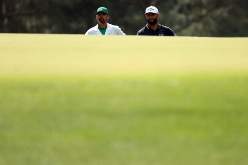 Rahm and his caddie, Adam Hayes, are seen on the third green Thursday.
