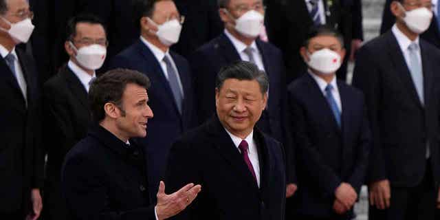 French President Emmanuel Macron, bottom left, chats with Chinese President Xi Jinping during a welcome ceremony held outside the Great Hall of the People in Beijing, on April 6, 2023. 