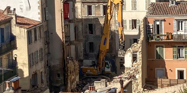 An excavator clears debris on the scene where a building collapsed, in Marseille, southern France, on Monday.