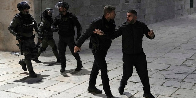 Israeli police lead a Palestinian away from the Al-Aqsa Mosque as many Muslims attempt to stay overnight during Ramadan.