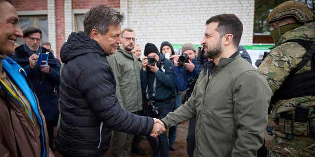 Ukrainian President Volodymyr Zelenskyy, right, shakes hands with German economy and climate minister Robert Habeck in the Chernihiv region of Ukraine, on April 3, 2023. Olaf Scholz's spokesman on April 5, 2023, defended his country's record on delivering arms to Ukraine after Habeck, a pre-war advocate of providing Ukraine with arms, said this week he was "deeply ashamed" that it took Germany so long to do so.