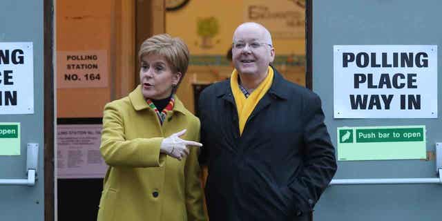 Scottish First Minister Nicola Sturgeon poses for the media with husband Peter Murrell, outside polling station in Glasgow, Scotland, on Dec. 12, 2019. British media are reporting that Murrell has been arrested in a finance probe on April 5, 2023. 