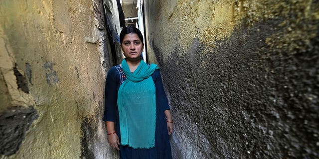 Sheela Singh, 39, stands in a narrow lane in Mumbai, India, on March 19, 2023. Singh was pressured to quit her job to care for her children as India continues to grapple with a shrinking female workforce. 