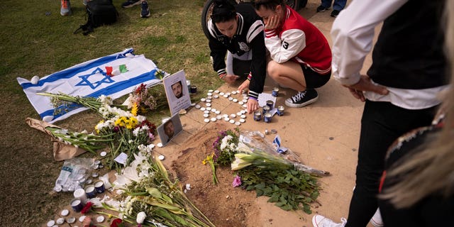 People gather and lay flowers at the site where Alessandro Parini, an Italian tourist, was killed in a Palestinian attack, in Tel Aviv, Israel, Saturday, April 8, 2023. Israeli authorities said an Italian tourist was killed and five other Italian and British citizens were wounded Friday when a car rammed into a group of tourists in Tel Aviv.