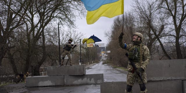 Ukrainian soldiers celebrate at a check point in Bucha, on the outskirts of Kyiv, Ukraine, Sunday, April 3, 2022. 