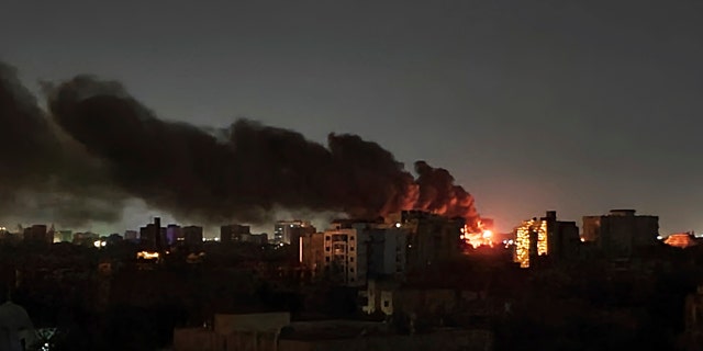 Smoke rises over the horizon as a fire burns after a strike in Khartoum, Sudan, Sunday, April 16, 2023. 