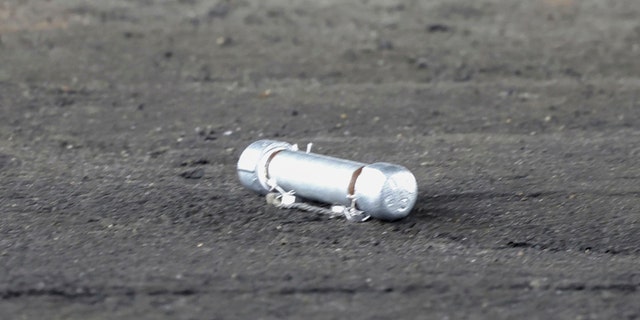 A suspicious object is seen on the ground where a suspect was arrested before Japanese Prime Minister Fumio Kishida was to begin his speech, at the Saikazaki port in Wakayama prefecture, western Japan, Saturday, April 15, 2023.   