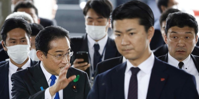 Japanese Prime Minister Fumio Kishida, left, surrounded by security police, arrives at the Saikazaki port for an election campaign event in Wakayama, western Japan Saturday, April 15, 2023. Kishida was evacuated unharmed Saturday after someone threw an explosive device in his direction while he was campaigning at the fishing port in western Japan, officials said.