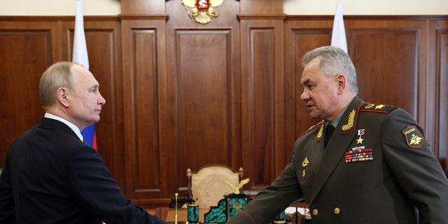 Russian President Vladimir Putin, left, and Russian Defence Minister Sergey Shoigu shake hands during their meeting at the Kremlin in Moscow, Russia, Monday, April 17, 2023. 
