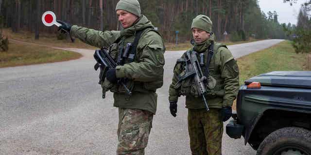 Lithuanian soldiers patrol a road near the Lithuania-Belarus border near the village of Jaskonys, Druskininkai district nearly 100 miles south of the capital Vilnius, Lithuania, on Nov. 13, 2021. 