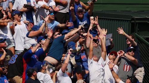 Fans scramble to catch a home run ball at Wrigley Field in Chicago in August 2022.