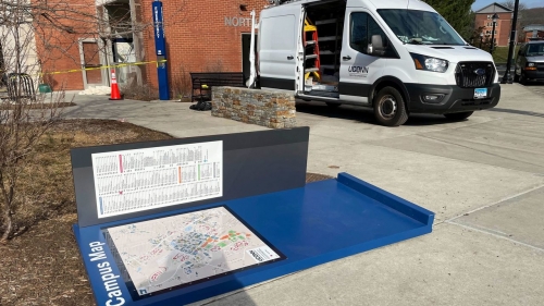 A toppled campus map and a repair vehicle on the University of Connecticut campus.