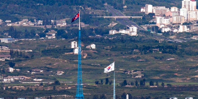 Flags of North Korea, rear, and South Korea, front, flutter in the wind as pictured from the border area between two Koreas in Paju, South Korea.