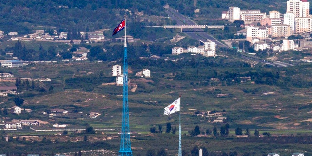 Flags of North Korea, rear, and South Korea, front, flutter in the wind as pictured from the border area between two Koreas in Paju, South Korea.