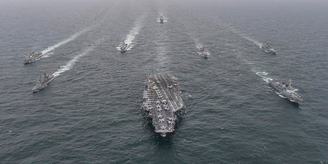 In this photo provided by the South Korea Defense Ministry, South Korean navy destroyer Yulgok Yi I, front row right, U.S. Navy aircraft carrier USS Nimitz, center, Japan Maritime Self-Defense Force's Umigiri, front row left, sail in formation during a joint naval exercise in international waters off South Korea's southern island of Jeju. North Korea has been speaking out against the drills.