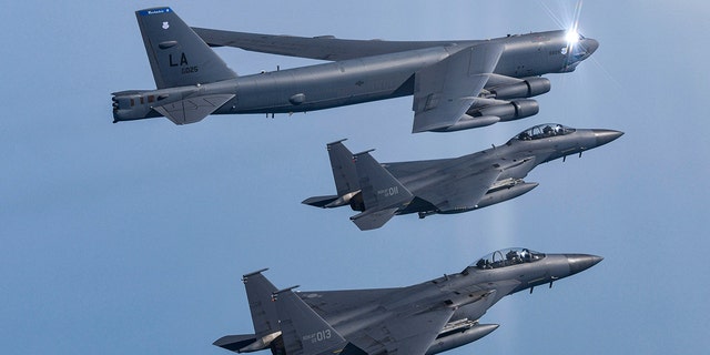 A U.S. Air Force B-52H Stratofortress aircraft, top, flies in formation with South Korea's Air Force F-15K fighters over the western sea of Korean peninsula during a joint air drill in South Korea.