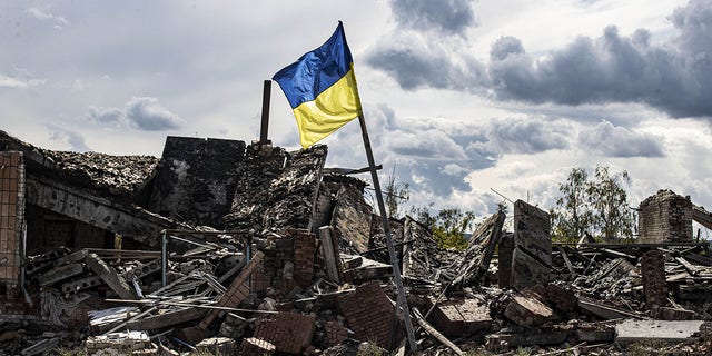 A Ukrainian flag waves in a heavily damaged residential area in the village of Dolyna in Donetsk Oblast, Ukraine, after the withdrawal of Russian troops on Sept. 24.