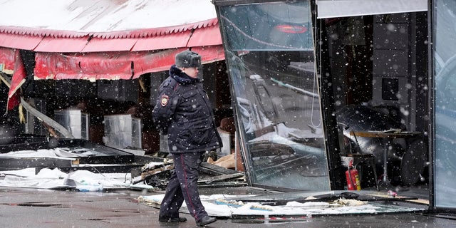 A police officer walks by the site of an explosion at the "Street Bar" café in St. Petersburg, Russia, on Monday, April 3, that killed well-known military blogger Vladlen Tatarsky a day earlier.