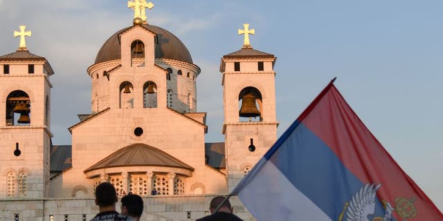 People attend a church-led protest in front of the Serbian Orthodox Church of Christ's Resurrection in Podgorica, on Aug. 23, 2020.