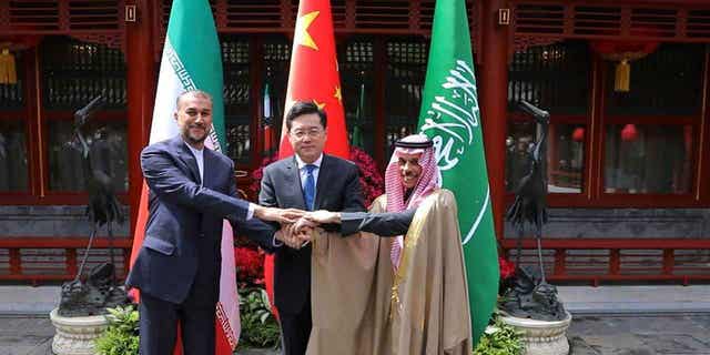 Iran's Foreign Minister Hossein Amirabdollahian, left, shakes hands with his Saudi Arabian counterpart Prince Faisal bin Farhan Al Saud, right, and Chinese counterpart Qin Gang in Beijing on April 6, 2023. 