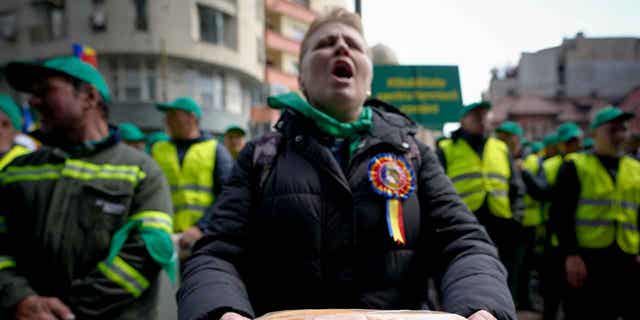 A woman holds a loaf of bread during a farmers protest in Bucharest, Romania, on April 7, 2023. Three European Union countries have placed a ban on food imports from Ukraine.