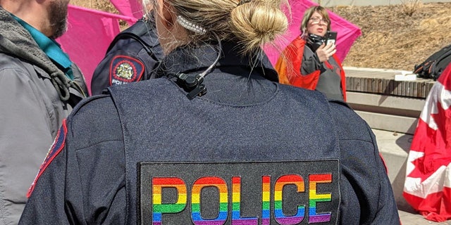 An officer at the Calgary event wears a vest emblazoned with "police" in rainbow letters.